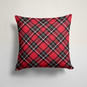 May include: Red and black plaid throw pillow with a white background. The pillow is made of a soft, comfortable fabric and is perfect for adding a touch of style to any room.