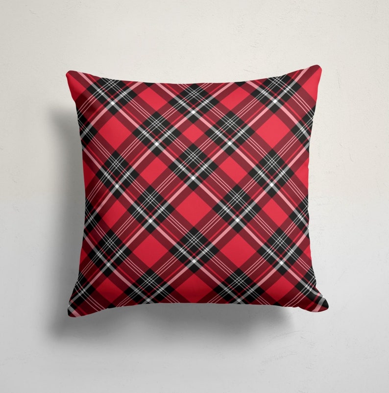 May include: Red and black plaid throw pillow with a white background. The pillow is made of a soft, comfortable fabric and is perfect for adding a touch of style to any room.
