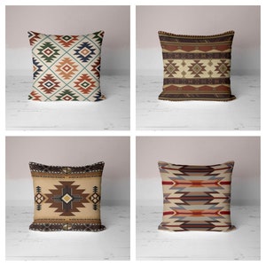 May include: Four decorative throw pillows with geometric patterns in shades of brown, red, blue, and beige. The pillows are arranged in a grid pattern on a white wooden surface.