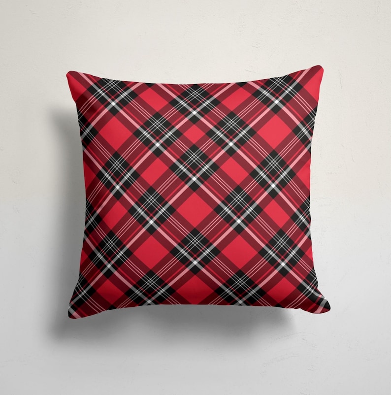 May include: Red and black plaid throw pillow with a white background. The pillow is made of a soft, comfortable fabric and is perfect for adding a touch of style to any room.
