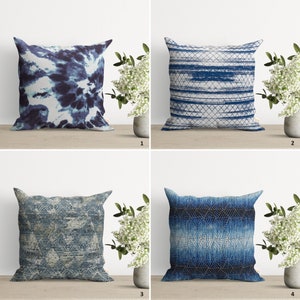 May include: Four different blue and white patterned throw pillows with a geometric design. The pillows are arranged in a grid pattern on a wooden surface.