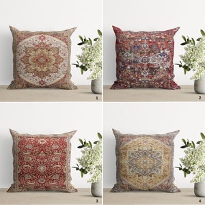 May include: Four decorative throw pillows with a traditional Persian rug pattern. The pillows are in shades of red, beige, and blue. The pillows are arranged in a row on a light brown surface.