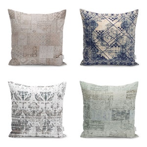 Op de afbeelding: Vier decoratieve kussens met verschillende patronen. De kussens zijn allemaal vierkant en hebben een lichte achtergrond met een donker patroon. De patronen omvatten een patchwork-ontwerp, een geometrisch ontwerp, een bloemenontwerp en een meer abstract ontwerp.