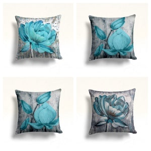 May include: Four decorative throw pillows with a grey and white background and blue floral designs. The pillows are square and have a soft, plush texture.
