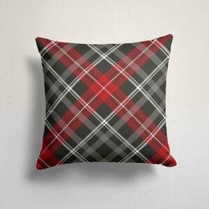 May include: Red, black, and white plaid throw pillow. The pillow is square and has a soft, plush texture.
