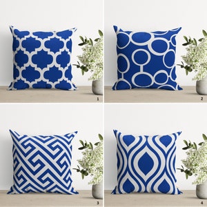 May include: Four blue and white throw pillows with different geometric patterns. The pillows are arranged in a grid pattern on a white surface.