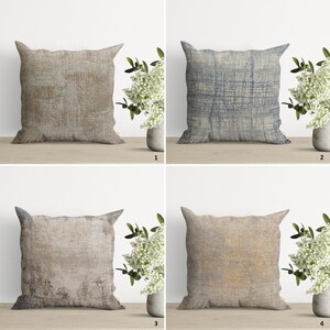 Op de afbeelding: Vier vierkante kussens met een verweerd, textuurrijk stoffen ontwerp. De kussens zijn in beige, bruin en blauwe tinten.