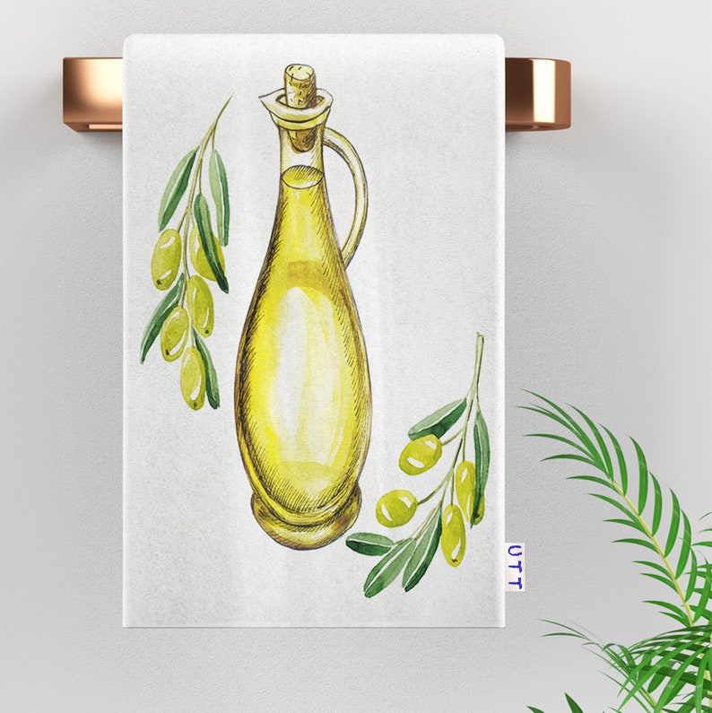 Tea Towel featuring a watercolor illustration of a glass bottle of olive oil with a cork stopper and green olive branches with green olives. The bottle is yellow and the branches are green. The background is white.