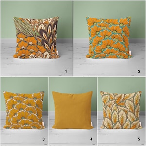 May include: Five different throw pillow designs featuring a variety of patterns in shades of orange, brown, green, and cream. The patterns include floral, paisley, and geometric designs.