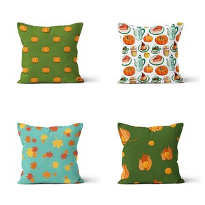 Peut inclure: Quatre coussins carrés avec des motifs sur le thème de l'automne. L'un des coussins présente des citrouilles oranges sur un fond vert. Un autre présente un motif de citrouilles, de théières et de parts de tarte. Le troisième a des feuilles colorées sur un fond turquoise, et le dernier a des fruits oranges sur un fond vert.