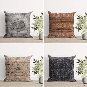 May include: Four decorative throw pillows with different patterns. Two pillows feature a distressed, faded, gray and black pattern. Two pillows feature a colorful, geometric pattern with red, orange, yellow, blue, and white accents.
