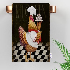 May include: A rooster wearing a chef's hat and apron holds a plate with a cake that says "Kitchen, the best place". The rooster is standing on a black and white checkered floor.