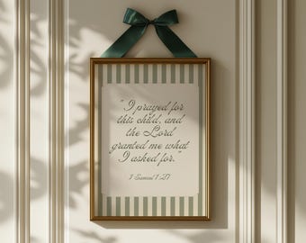 May include: A framed print with a gold frame and a green and white striped background. The print features a quote from the Bible, 1 Samuel 1:27, which reads "I prayed for this child, and the Lord granted me what I asked for."