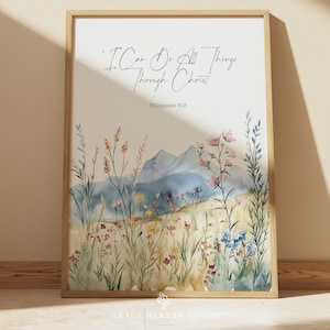 May include: Framed watercolor print featuring a field of wildflowers and mountains. The artwork includes the text "I Can Do All Things Through Christ" from Philippians 4:13. The print is in a wooden frame.