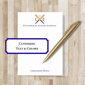 May include: White notepad with baseball-themed graphics, including crossed bats, a baseball, and the text "I'd rather be playing baseball." The notepad also features the text "Customize Text & Colors" and "Christopher Davis." A gold pen rests on the notepad.