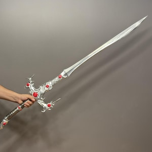 May include: A silver sword with a decorative handle and red gems. The sword has a long, straight blade and a pointed tip.
