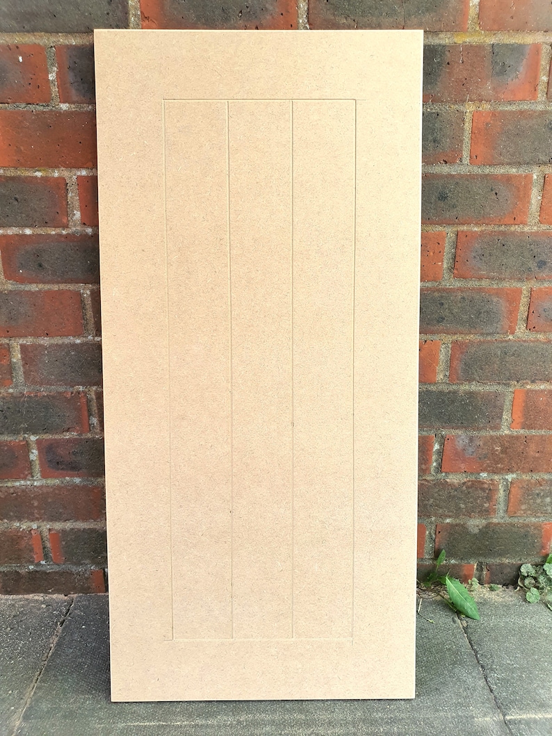 K&ouml;nnte beinhalten: Eine hellbraune Holzt&uuml;r f&uuml;r einen Schrank mit vertikalem Paneeldesign. Die T&uuml;r ist aus mitteldichter Faserplatte (MDF) gefertigt und hat eine glatte, unbehandelte Oberfl&auml;che.