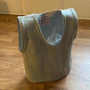 May include: A light blue sleeveless undershirt with a white tag that reads "HARVEY" and "Made in Canada".