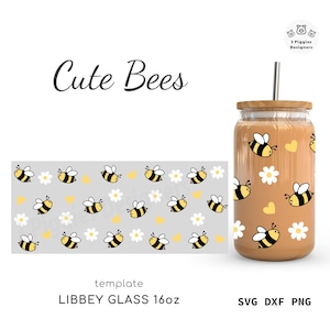 May include: A 16oz Libbey glass with a wooden lid and a stainless steel straw. The glass is decorated with yellow and black bees, white daisies, and yellow hearts. The words "Cute Bees" are written in cursive.