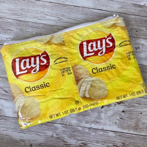 May include: A yellow Lay's potato chips bag with the text "Lay's Classic" and "NET WT. 1 OZ (28.3 g) ATO CHIPS".