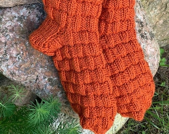 May include: A pair of hand-knitted socks in a rich orange color. The socks have a textured, waffle-like pattern.