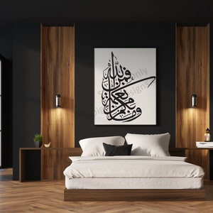 Könnte beinhalten: Ein weißer Leinwanddruck mit schwarzer arabischer Kalligraphie auf weißem Hintergrund. Der Druck hängt an einer schwarzen Wand in einem Schlafzimmer mit einem weißen Bett und Holz-Nachttischen.