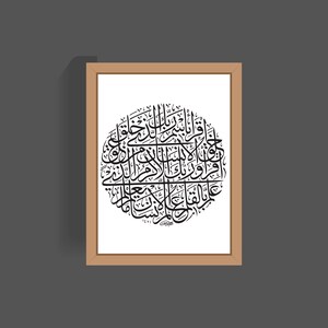 May include: A framed print of a black and white Islamic calligraphy design in a circle. The design is in a traditional Arabic script.