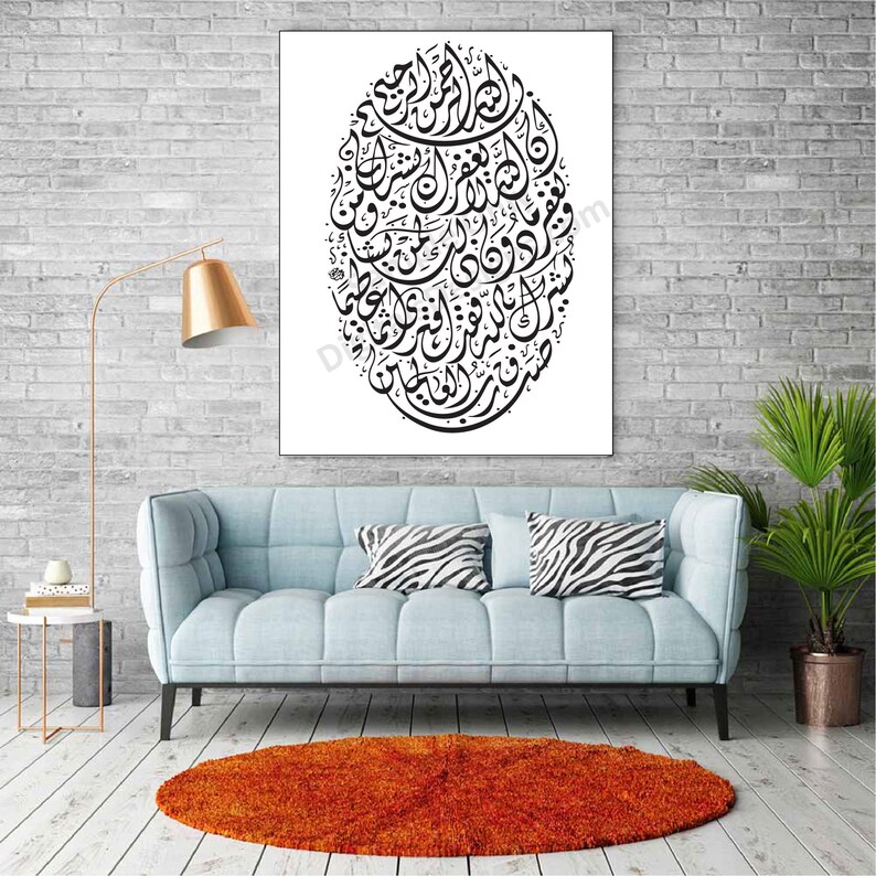 Op de afbeelding: Een zwart-witte islamitische kalligrafie-kunstprint met een cirkelvormig ontwerp met Arabische schrift. De print is ingelijst en hangt aan een witte bakstenen muur.