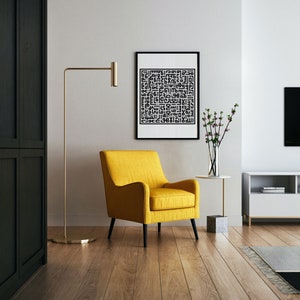 May include: A yellow armchair with black legs sits in a living room with a black and white framed print on the wall, a gold floor lamp, a small table with a vase of flowers, and a white entertainment center with a television.