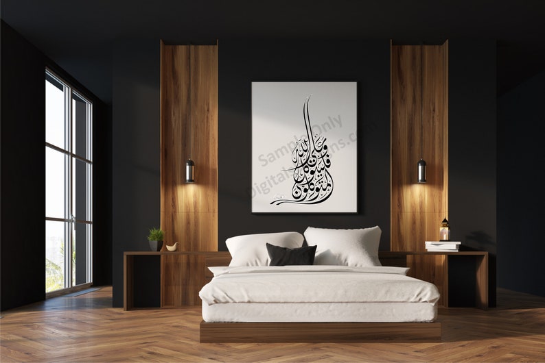 Op de afbeelding: Een witte canvasprint met zwarte Arabische kalligrafie hangt boven een wit bed met een zwart hoofdeinde in een moderne slaapkamer met donker houten lambrisering en een groot raam.