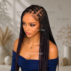 May include: A wig featuring long, dark brown box braids with subtle purple highlights. The hair is styled with a defined center part and neat, square-shaped sections at the scalp. The wig is worn with a dark blue, long-sleeved, ruched-front top.