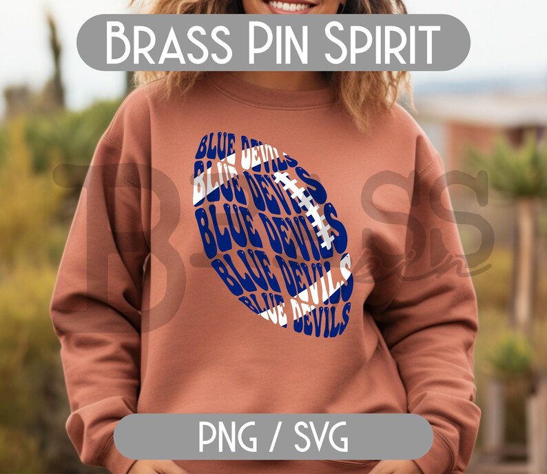 May include: A rust-colored sweatshirt featuring a blue and white football design with the words "BLUE DEVILS" repeated. The text "BRASS PIN SPIRIT" is above the design. The bottom of the image has the text "PNG / SVG".