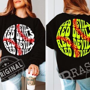 Puede incluir: Sudadera negra con diseño de béisbol. La parte delantera presenta un gráfico de béisbol blanco y rojo con las palabras "RED DEVILS" en un patrón circular. La parte trasera tiene un diseño similar en verde neón.