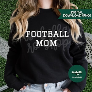 Może przedstawiać: Czarna bluza z długim rękawem z białym napisem FOOTBALL MOM wyśrodkowanym na klatce piersiowej. Odzież posiada okrągły dekolt i prążkowane mankiety. Zielony baner w prawym górnym rogu zawiera napis DIGITAL DOWNLOAD (PNG), a zielone koło zawiera napis isabella ro PRINTABLES.