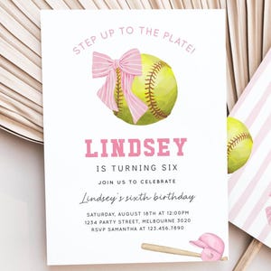 May include: A white birthday invitation card featuring a yellow softball with a pink striped bow, a pink baseball bat and helmet, and the text: STEP UP TO THE PLATE! LINDSEY IS TURNING SIX, JOIN US TO CELEBRATE, LINDSEY'S SIXTH BIRTHDAY, SATURDAY, AUGUST 16TH AT 12:00PM.