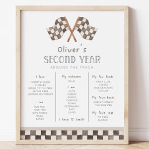 Könnte beinhalten: Ein druckbarer Poster mit einem karierten Flaggenmuster und dem Text "Oliver's Second Year Around the Track". Der Poster listet Olivers Lieblingsdinge auf, darunter Essen, Bücher und Spielzeug.