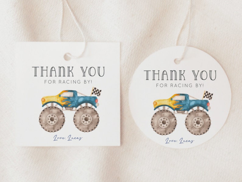 May include: Two thank you tags with a monster truck design. The tags are white with black text that says "Thank You for Racing By!" and "Love, Incas". The monster truck is blue, yellow, and gray with flames on the side.