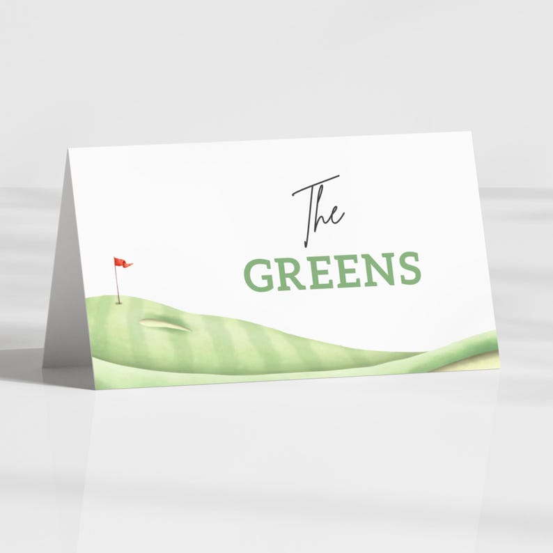 May include: A folded white card with the words "The GREENS" in black and green. The card features a watercolour illustration of a golf green with a red flag. The design is simple and elegant, perfect for golf-themed events.