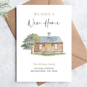 May include: A card with a watercolour illustration of a house, with the text "WE HAVE A New Home". The house is brown with a blue roof and a yellow door. The card includes the family name and address.