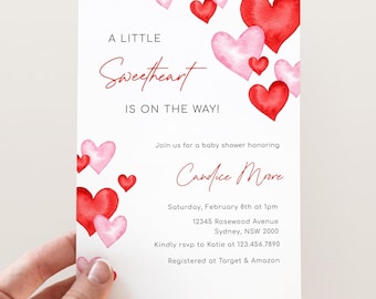 Puede incluir: Una invitación a una fiesta de bienvenida al bebé con un diseño de acuarela de corazones rosas y rojos. El texto dice "A Little Sweetheart is on the Way!" e incluye el nombre "Candice Moore", la fecha y hora de la fiesta, la dirección y la información de RSVP.