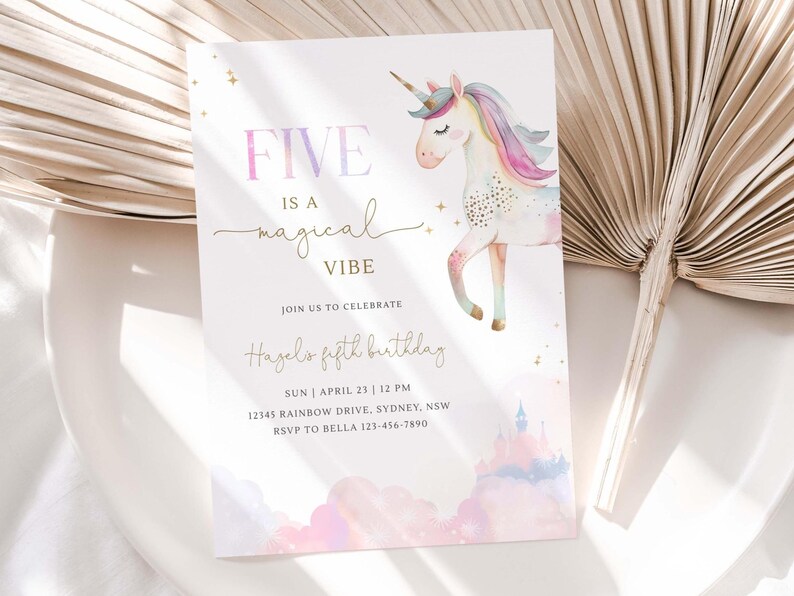 May include: A birthday invitation with a watercolor unicorn illustration. The text reads "FIVE is a magical VIBE" in a mix of fonts. Additional text includes the birthday girl's name, date, time, and address.