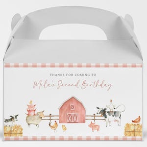 Può includere: Una scatola portaconfetti in gingham rosa e bianco con un'illustrazione ad acquerello di un fienile rosso, animali da fattoria e il testo "Grazie per essere venuto al secondo compleanno di Mila."