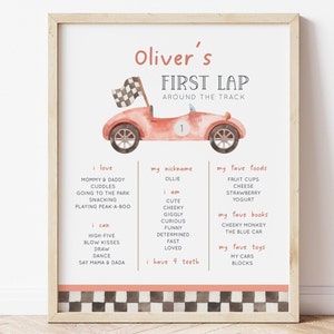 May include: A pink racing car with a chequered flag on top, surrounded by a white border with black chequered squares. The text "Oliver's First Lap Around The Track" is at the top of the image. The image also includes a list of things Oliver loves, his nickname, his favourite foods, books, and toys.
