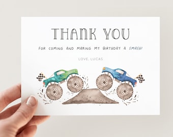Puede incluir: Tarjeta blanca con la frase "THANK YOU" en negro. Debajo, el texto dice "FOR COMING AND MAKING MY BIRTHDAY A SMASH!" y "LOVE, LUCAS". La tarjeta presenta ilustraciones de acuarela de dos monster trucks, uno verde y otro azul.