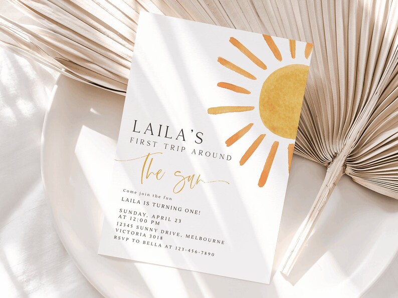 Peut inclure: Une invitation blanche avec un graphique de soleil jaune. Le texte indique "LAILA'S FIRST TRIP AROUND THE SUN. Come join the fun LAILA IS TURNING ONE! SUNDAY, APRIL 23 AT 12:00 PM 12345 SUNNY DRIVE, MELBOURNE VICTORIA 3018 RSVP TO BELLA AT 123-456-7890"