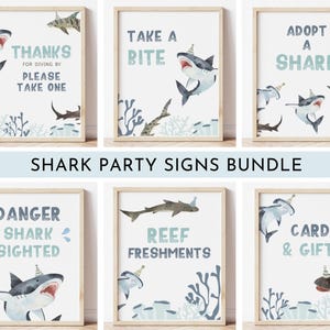 Peut inclure: Ensemble de six panneaux de fête sur le thème des requins, encadrés et illustrés à l'aquarelle. Chaque panneau présente un requin avec un chapeau de fête et du texte tel que "Merci", "Prenez une bouchée" et "Adoptez un requin".