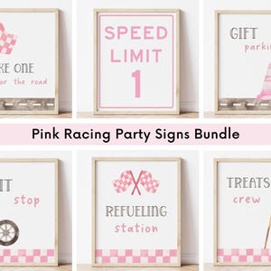 May include: A set of six framed pink racing party signs. The signs include phrases like "Take One for the Road," "Speed Limit 1," and "Gift Parking." Each sign has a watercolor design with a checkered flag, race car, or other racing-themed elements.