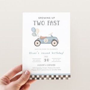 May include: A blue and white birthday invitation with a cartoon illustration of a blue toy car with balloons. The text reads "Growing Up Two Fast" and "Oliver's second birthday!" with the date and time of the party.