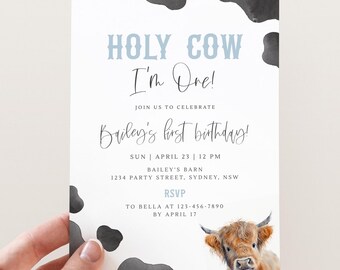 Puede incluir: Una invitación de cumpleaños con estampado de vaca en blanco y negro con el texto "HOLY COW I'm One!" y "Bailey's first birthday!" La invitación también incluye la fecha y hora de la fiesta, la ubicación y la información de RSVP.