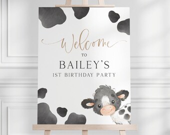 Peut inclure: Une pancarte d'accueil pour le 1er anniversaire de Bailey avec une illustration de vache noire et blanche. La pancarte a un fond blanc avec des taches de vache noires.